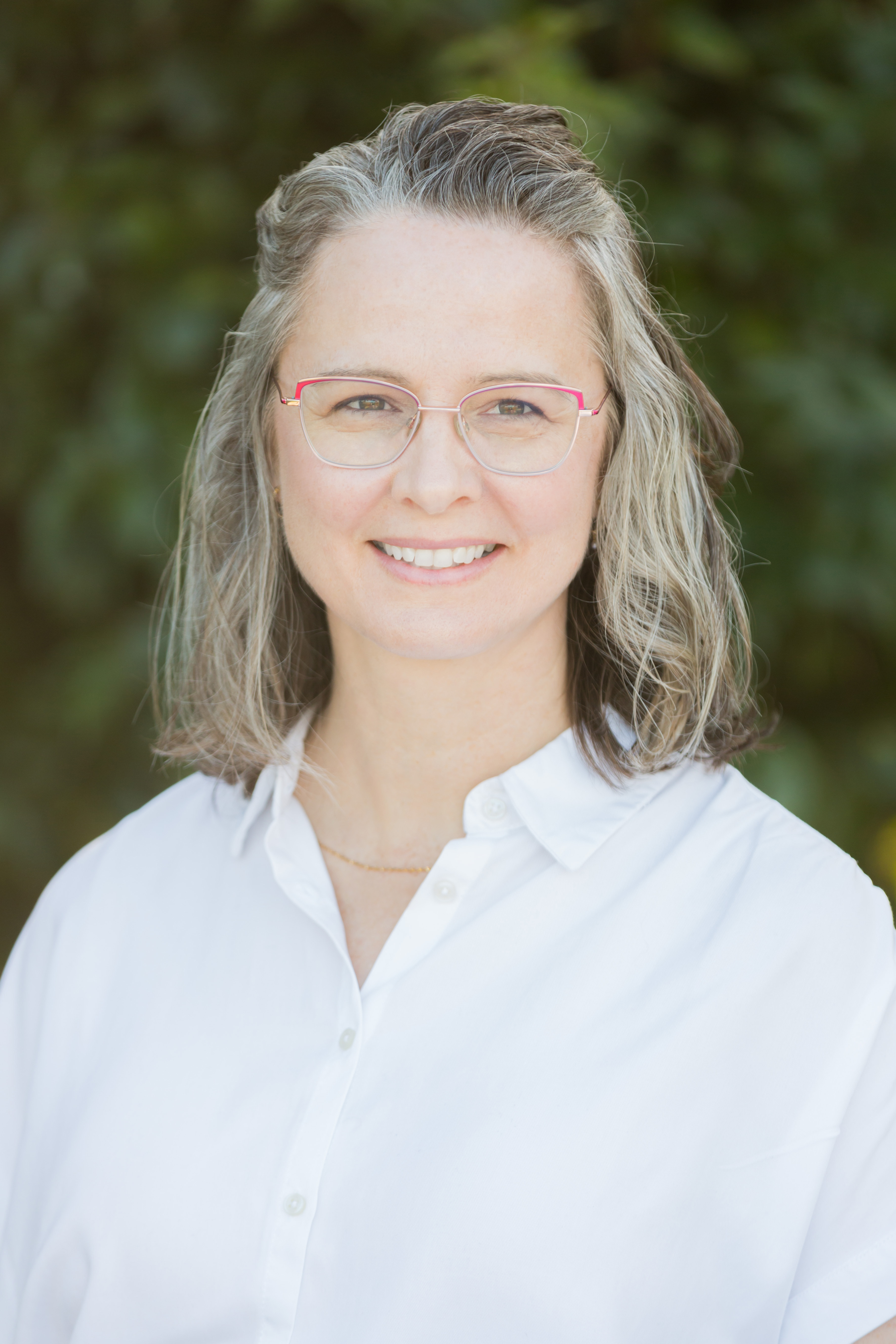 Women in a white shirt smiling outside